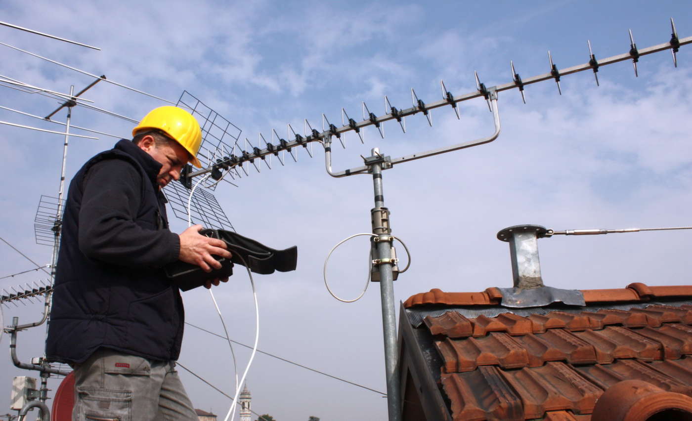 Antennista su tetto con misuratore di campo